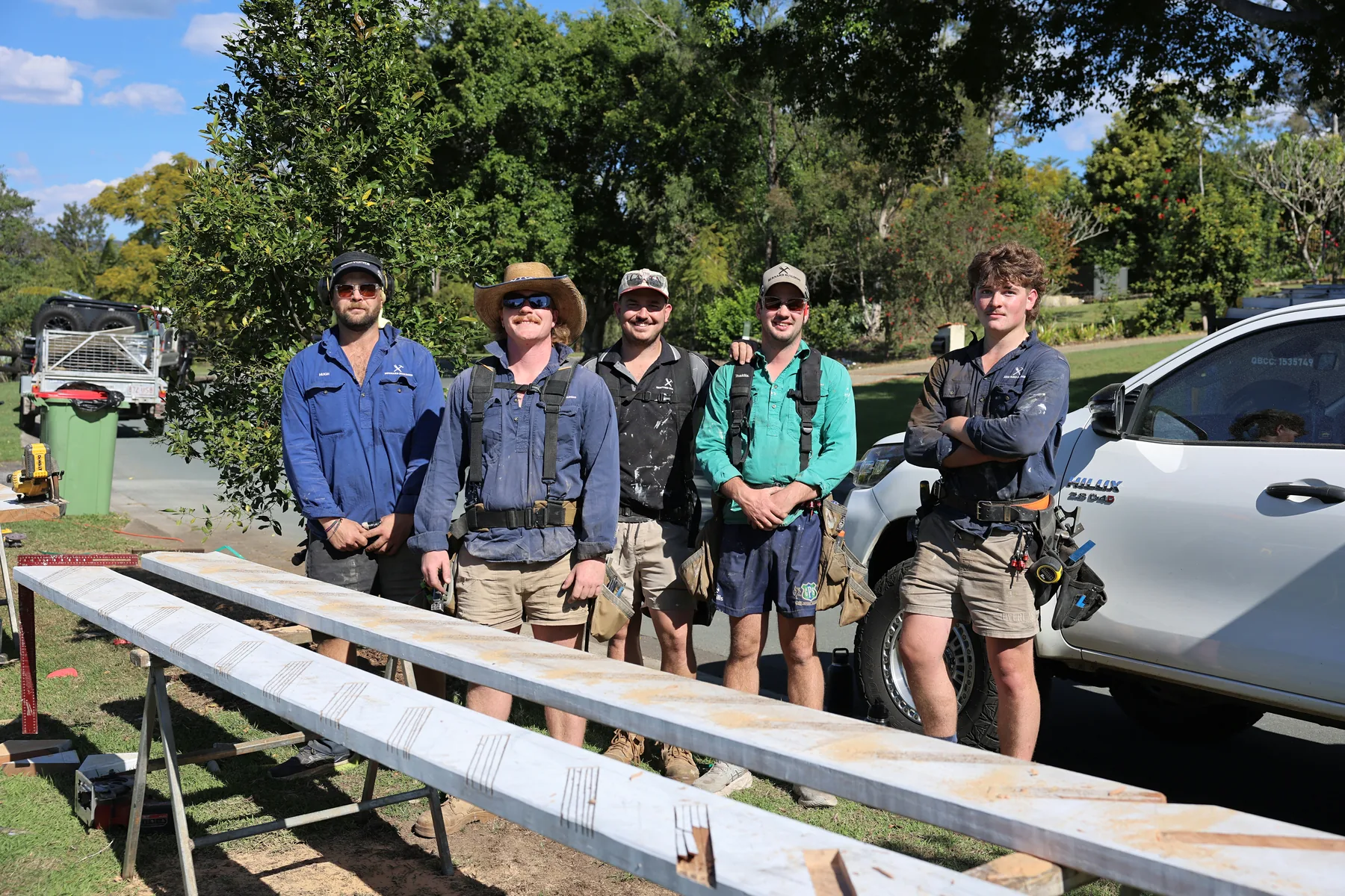 Ben Bernard, in the green shirt, with the Bernard Building crew beside the work ute, timber laid out on saw horses