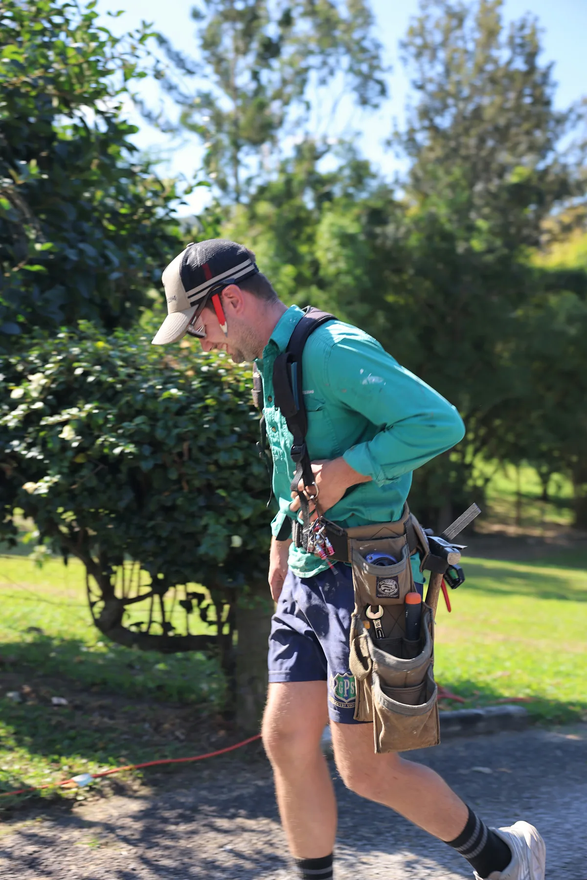 A Bernard Building carpenter walking the site with a loaded tool belt