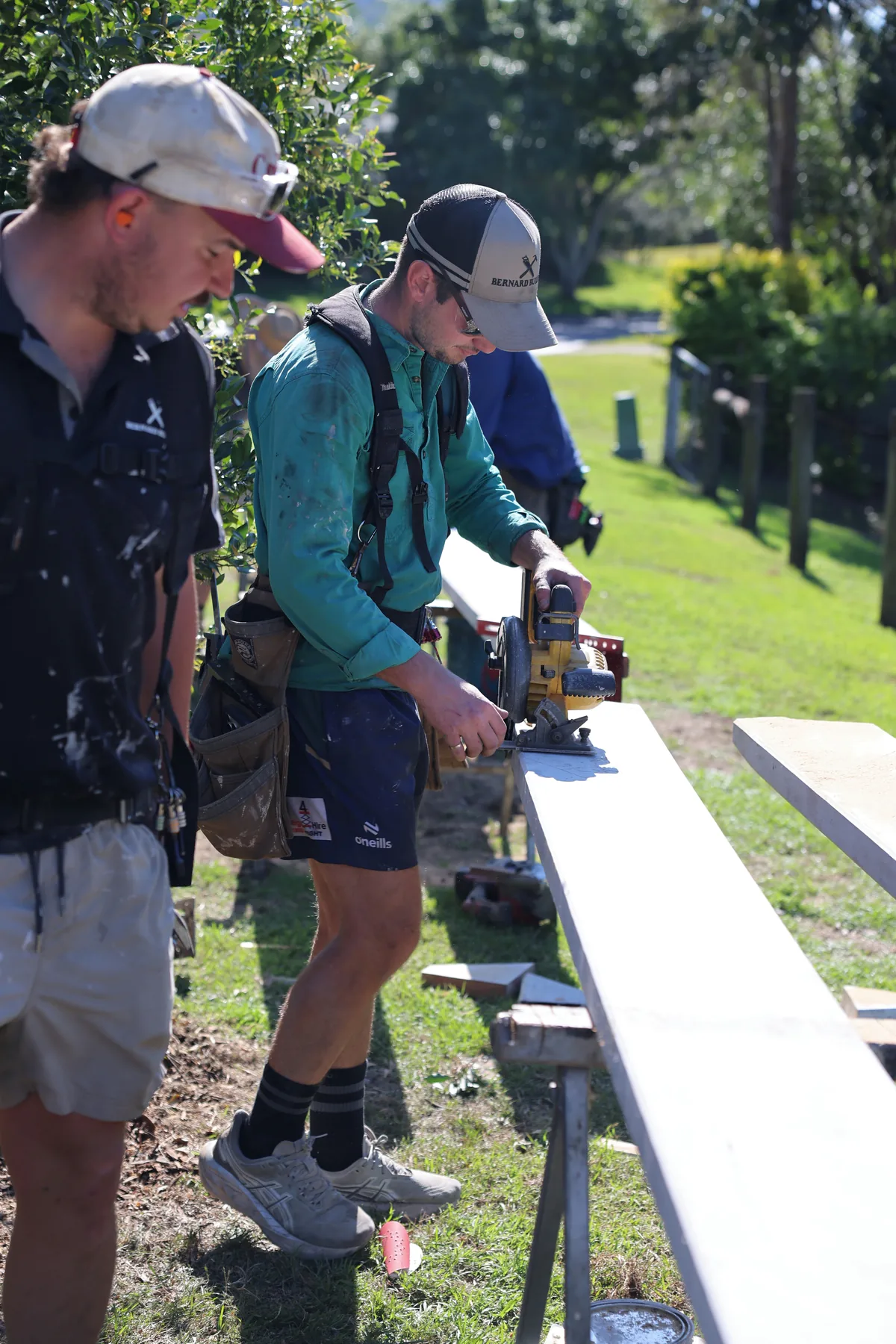 Ben Bernard cutting a board to length with the circular saw while one of the crew looks on