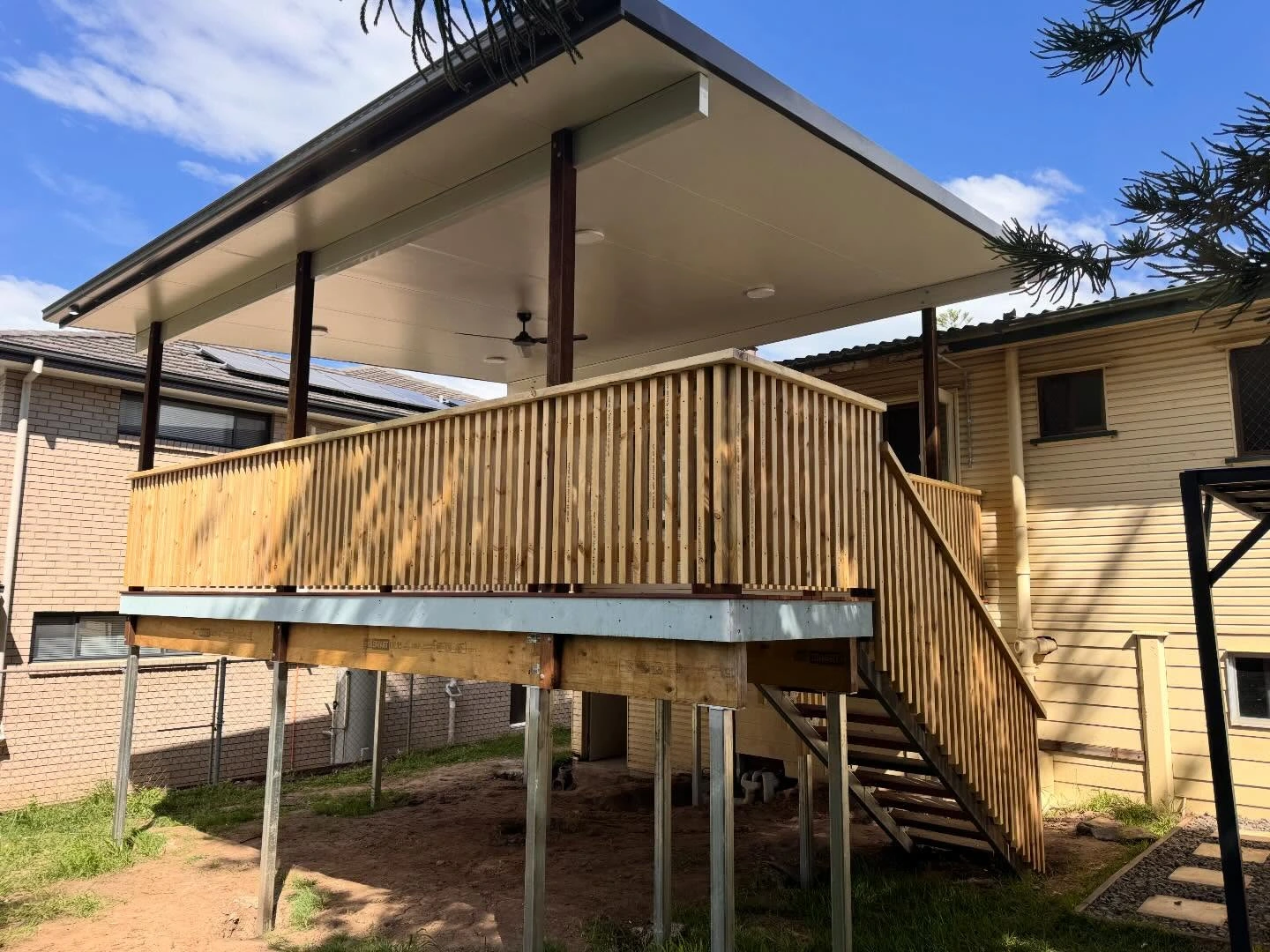 New deck under an insulated patio roof behind a Brisbane home